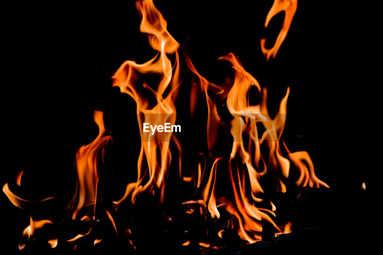 CLOSE-UP OF BONFIRE AGAINST BLACK BACKGROUND