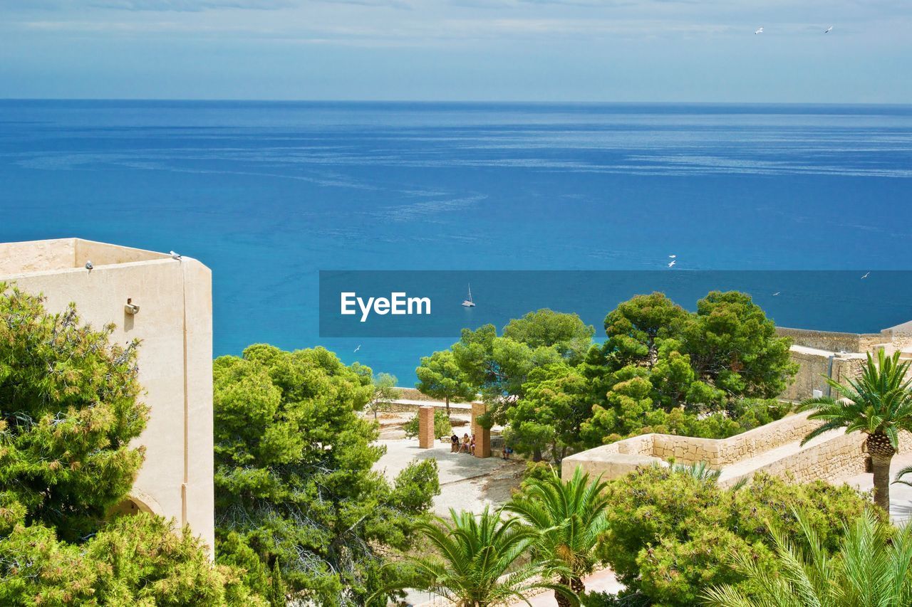 HIGH ANGLE VIEW OF SWIMMING POOL AGAINST SEA