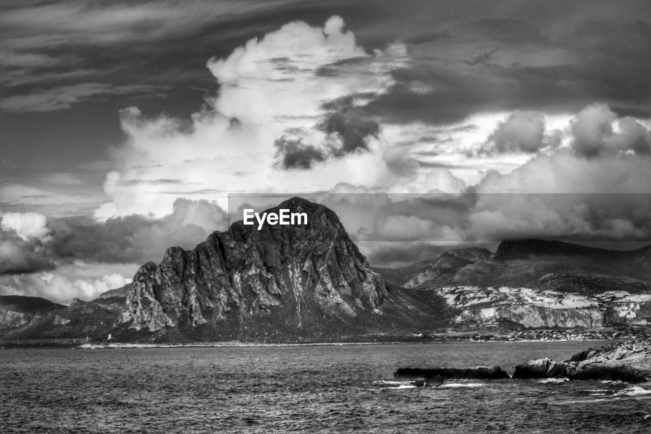 Scenic view of sea and mountains against sky