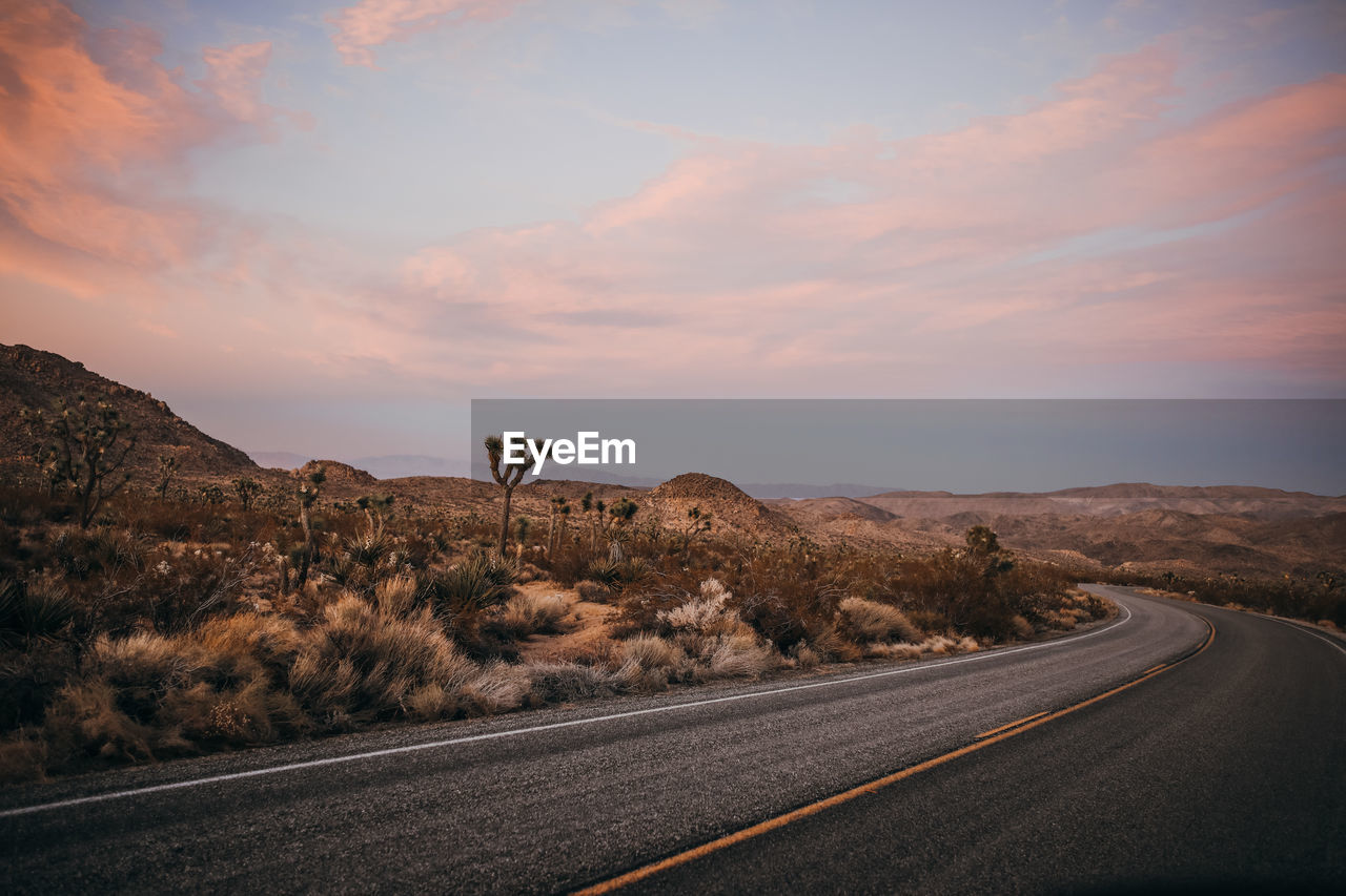 Windy road around mojave desert of joshua tree national park at sunset