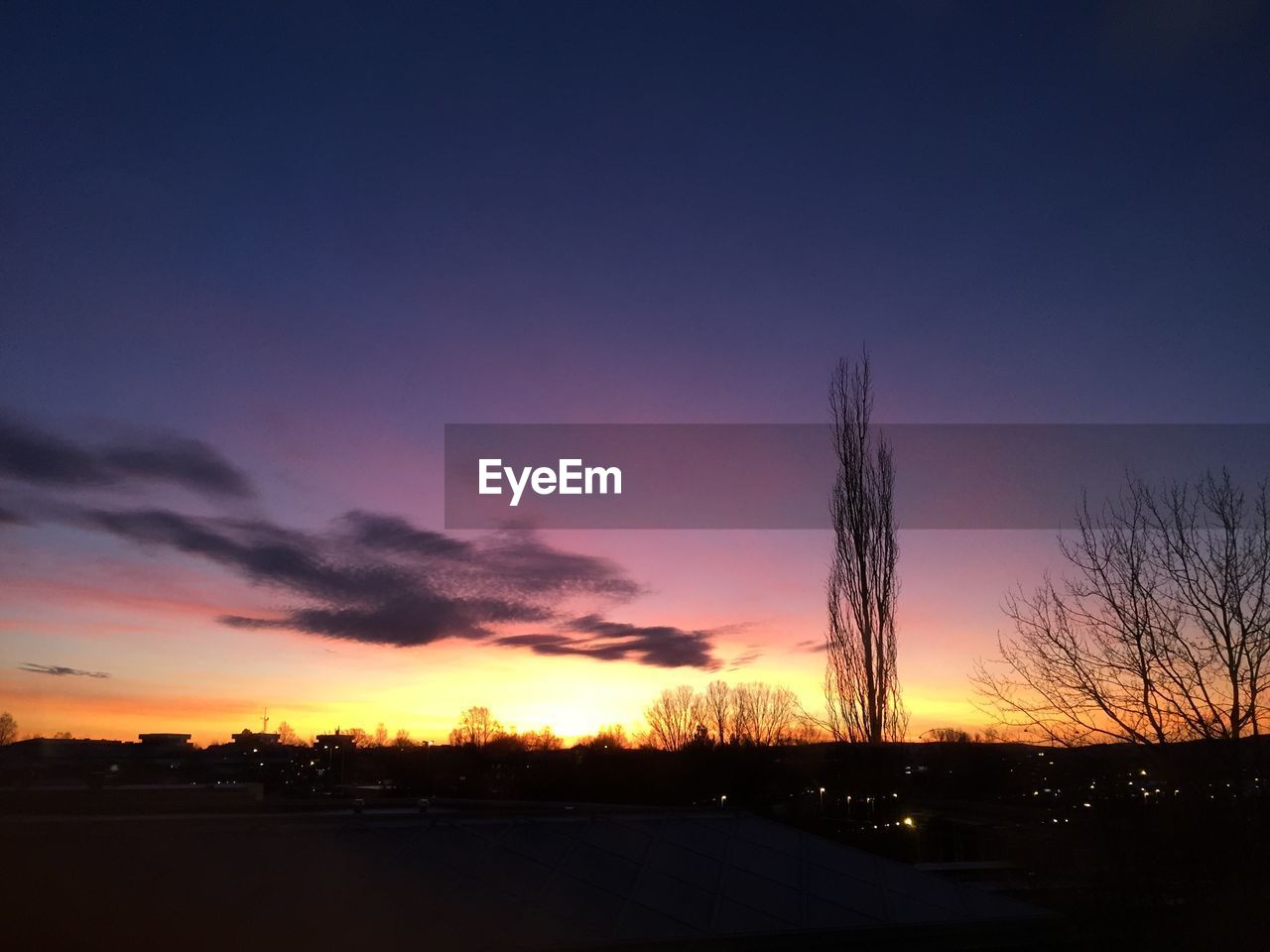 Silhouette landscape against dramatic sky during sunset