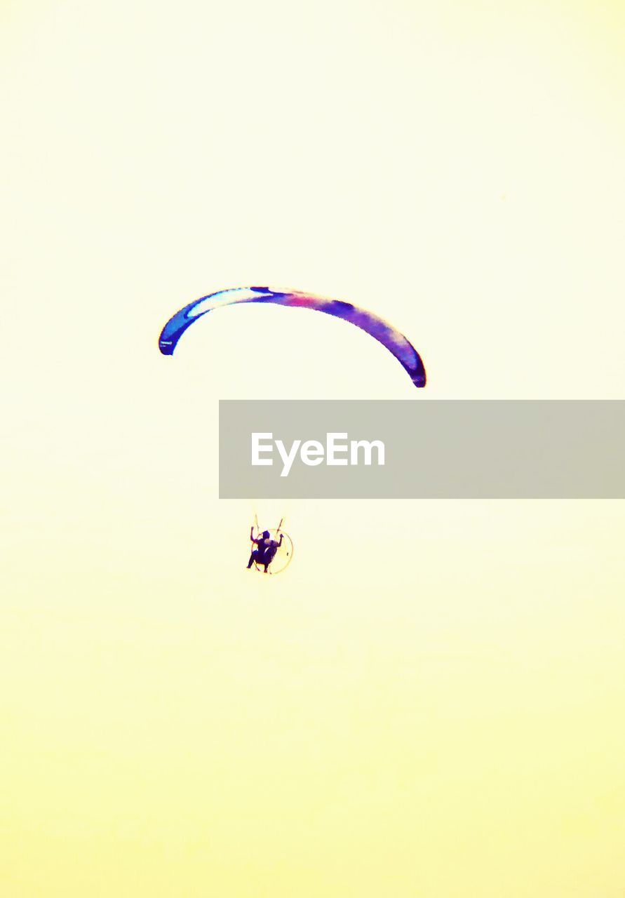 Low angle view of person with parachute against sky