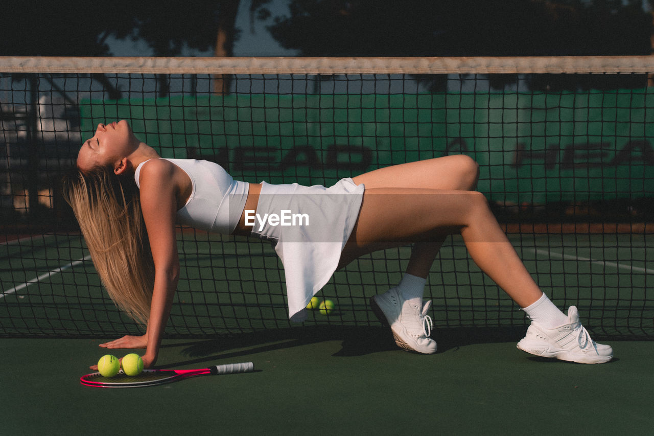 A woman exercising at tennis court 