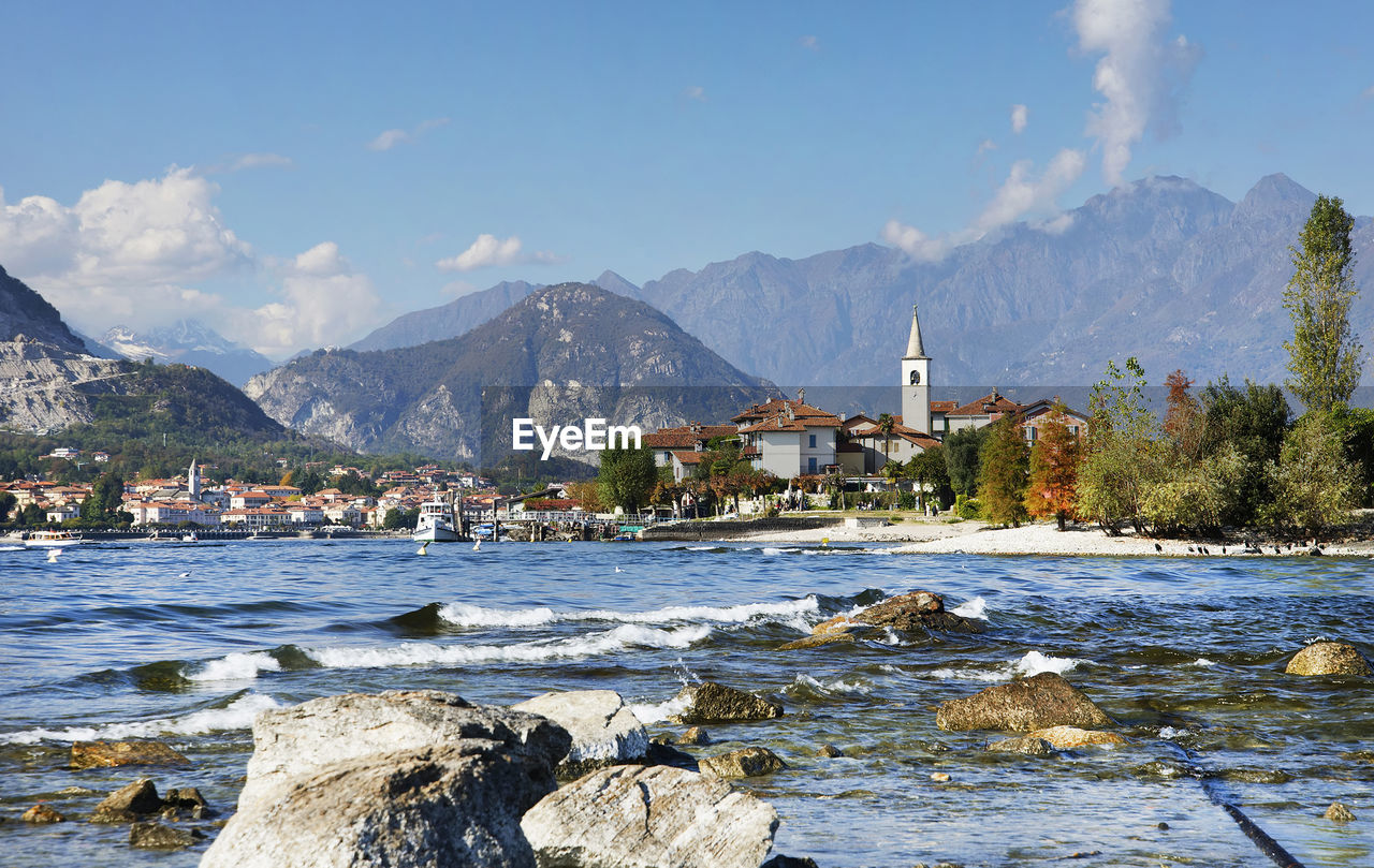 Scenic view of sea by buildings against sky