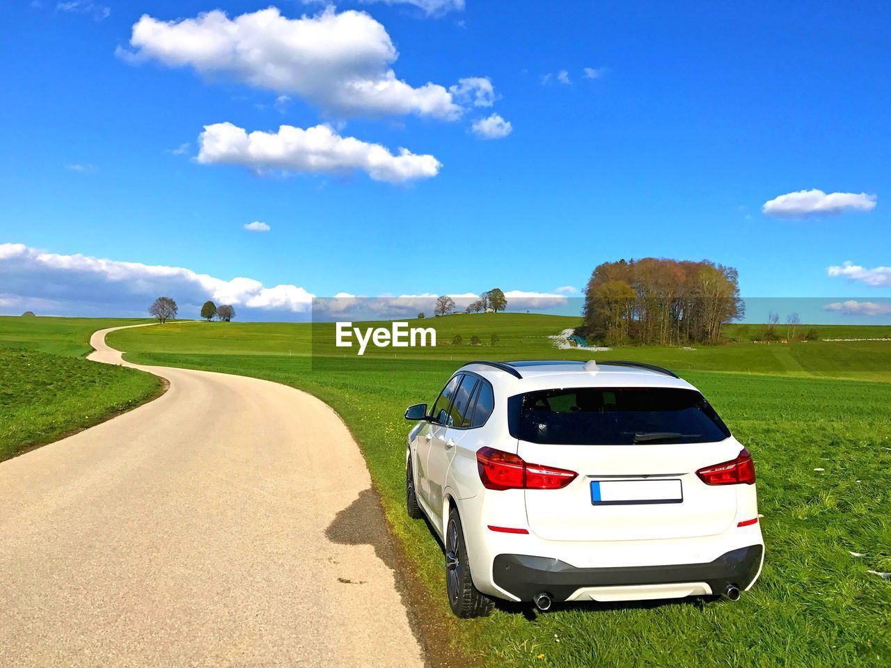 ROAD BY FIELD AGAINST SKY