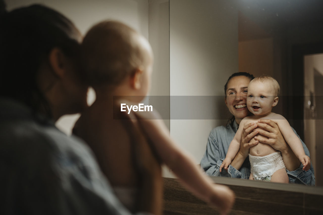 Mother and baby looking in mirror after shower