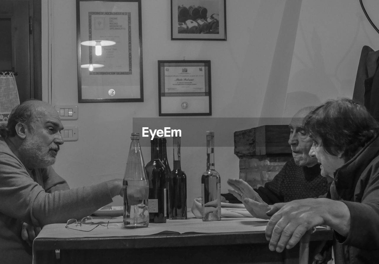 PORTRAIT OF FRIENDS SITTING AT TABLE