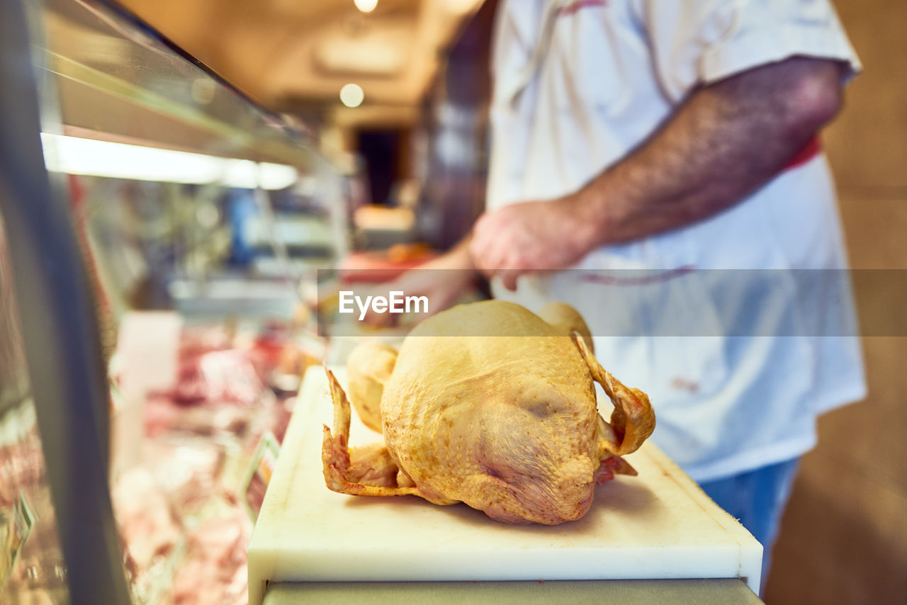 midsection of man cutting bread