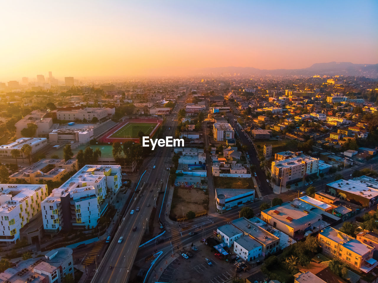 High angle view of street amidst buildings against sky during sunset