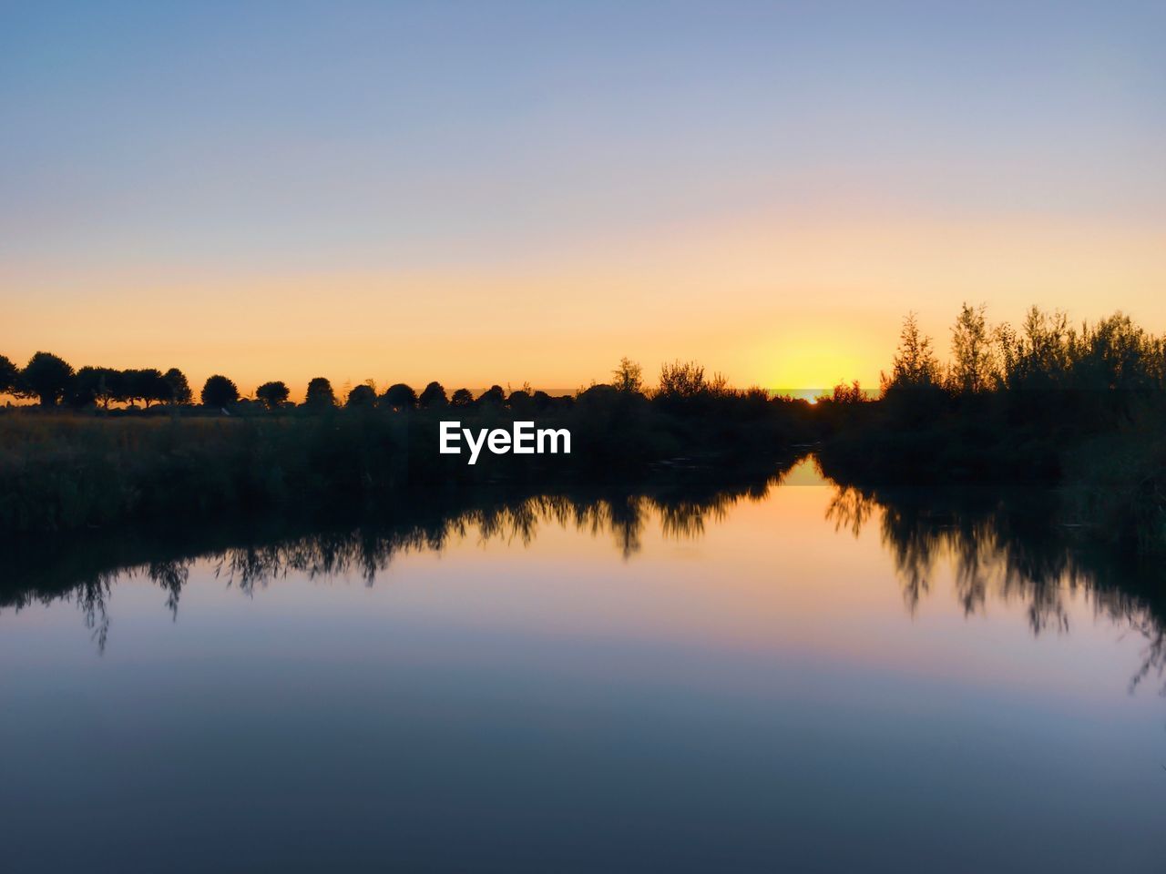 Scenic view of lake against sky during sunset