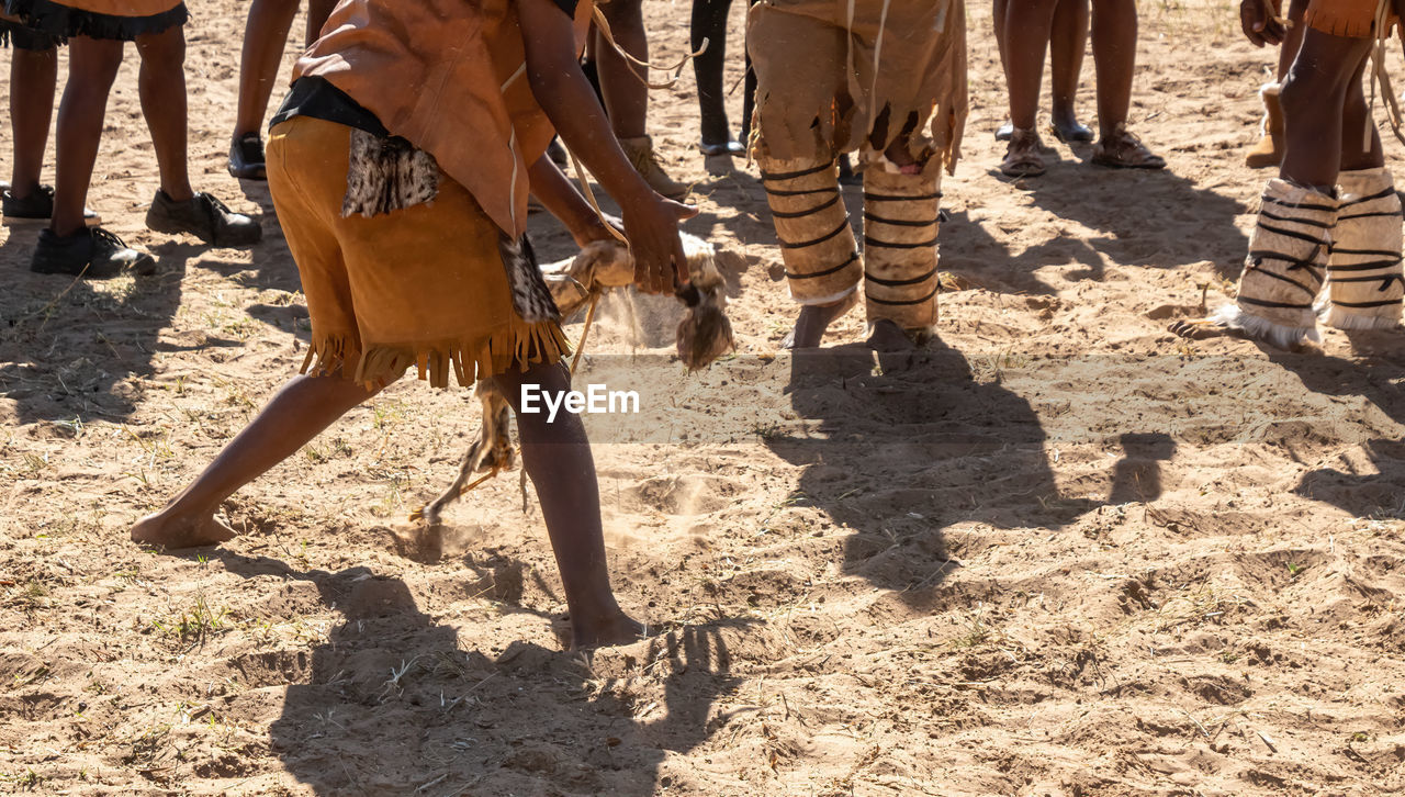 Low section of people standing over sand