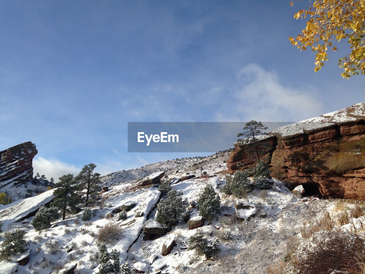 Low angle view of snow covered mountain against blue sky