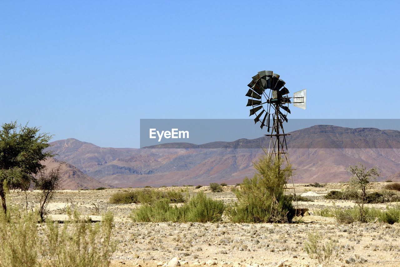 Scenic view of desert against clear blue sky