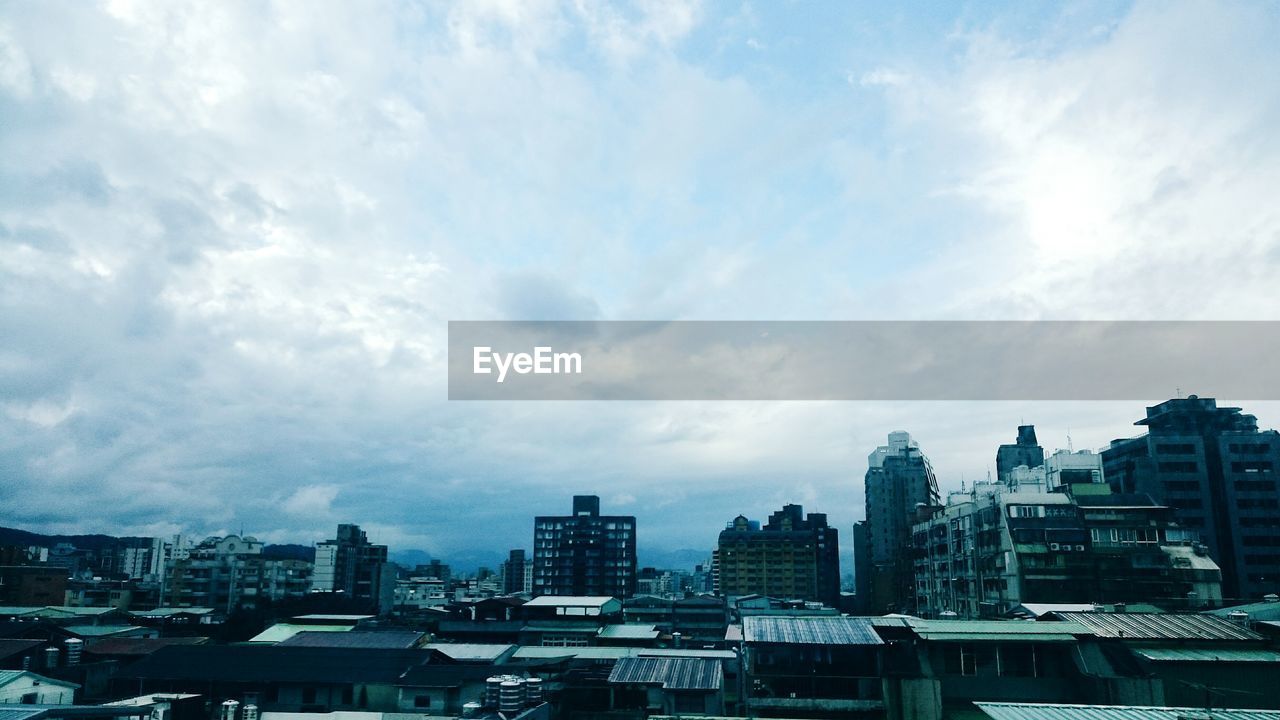 Cityscape against cloudy sky