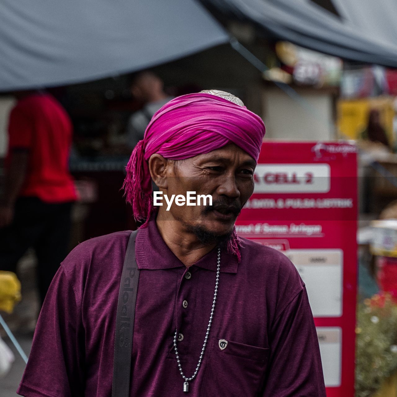 Mature man looking away while standing in market