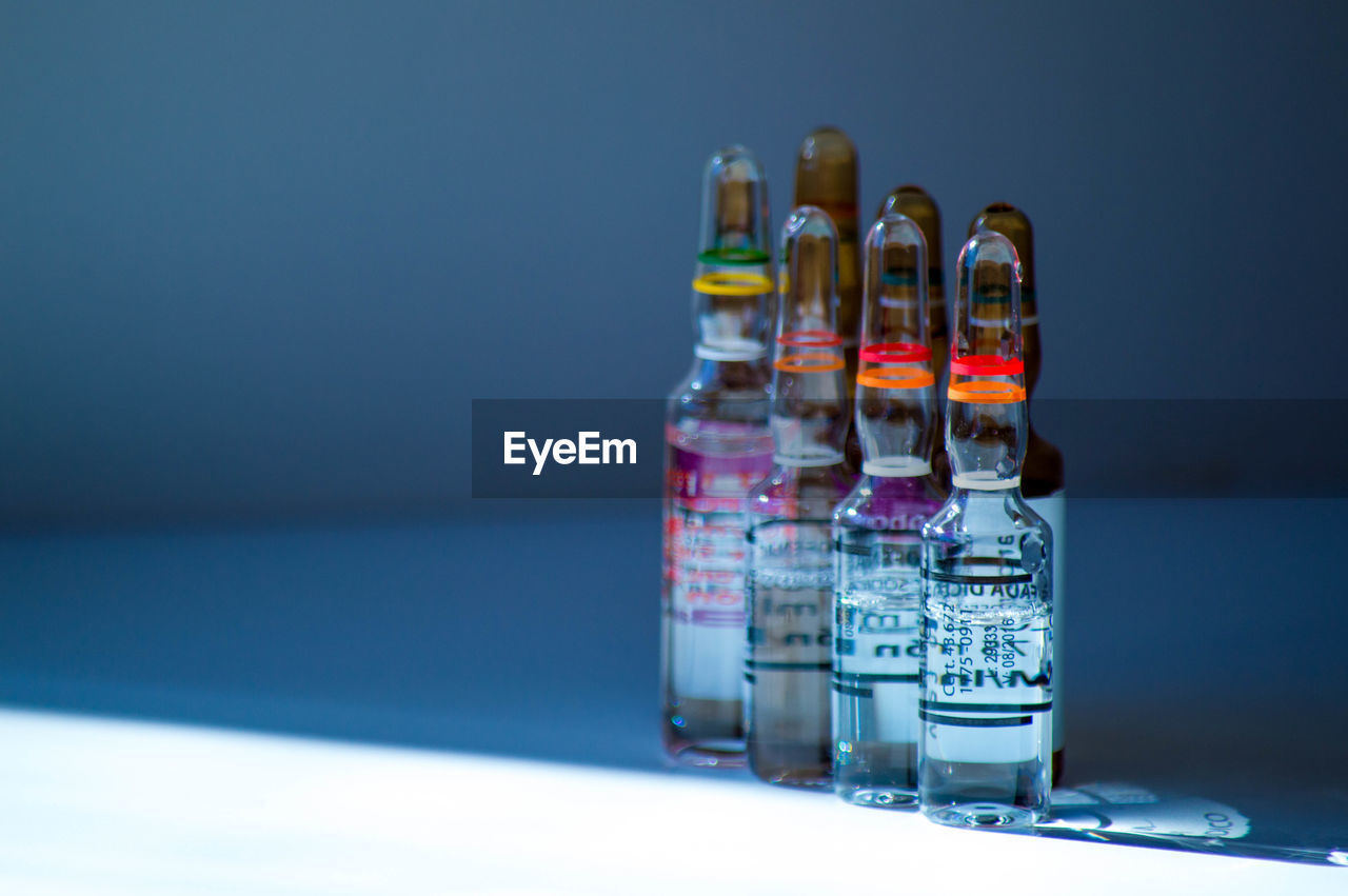 blue, container, studio shot, bottle, indoors, distilled beverage, no people, drink, alcohol, colored background, healthcare and medicine, alcoholic beverage, still life