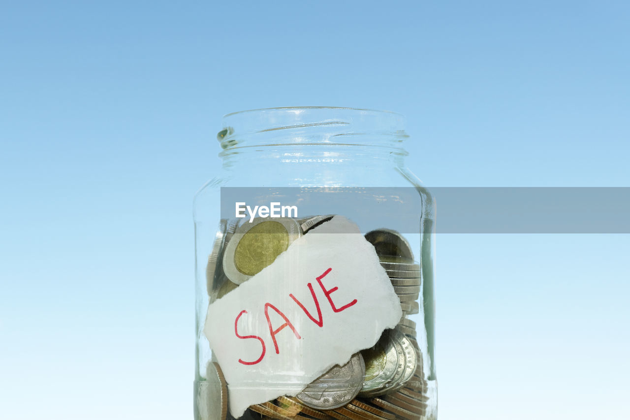 CLOSE-UP OF INFORMATION SIGN IN JAR AGAINST CLEAR SKY