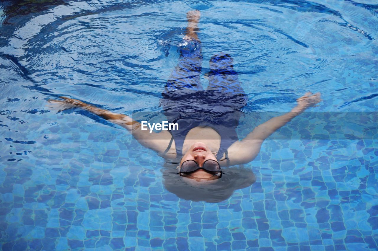 High angle view of young woman swimming in pool