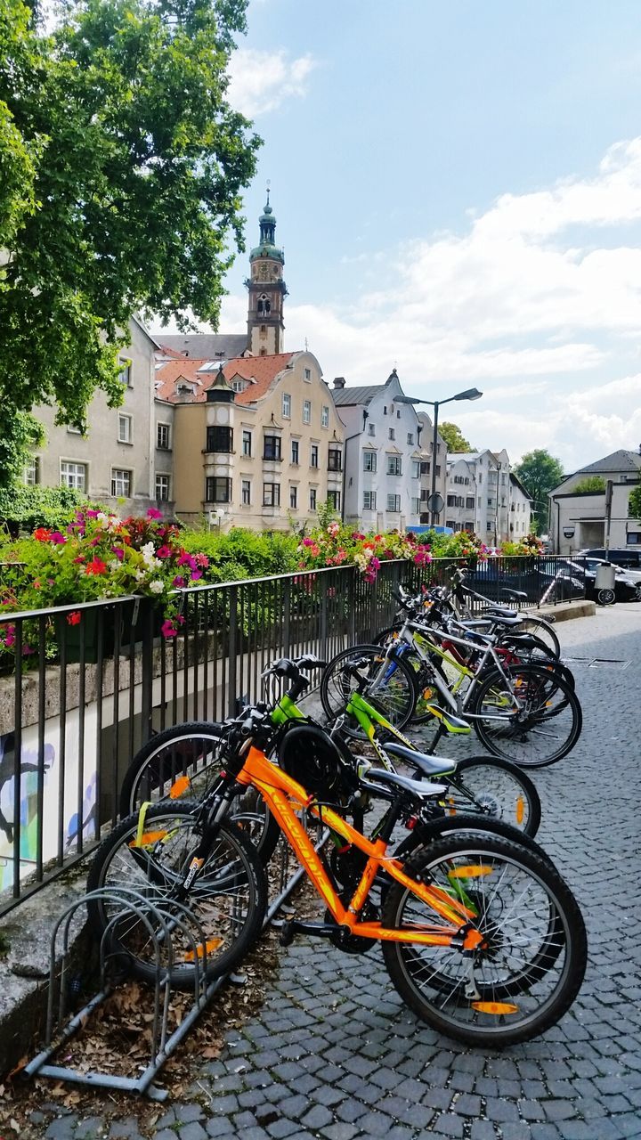 BICYCLES PARKED ON STREET BY BUILDINGS