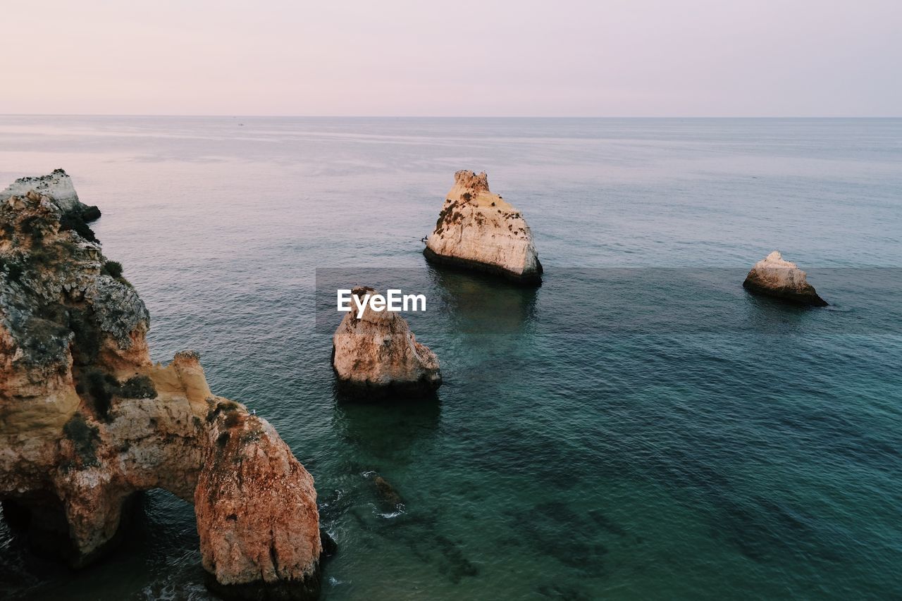 Scenic view of rocks in sea against sky