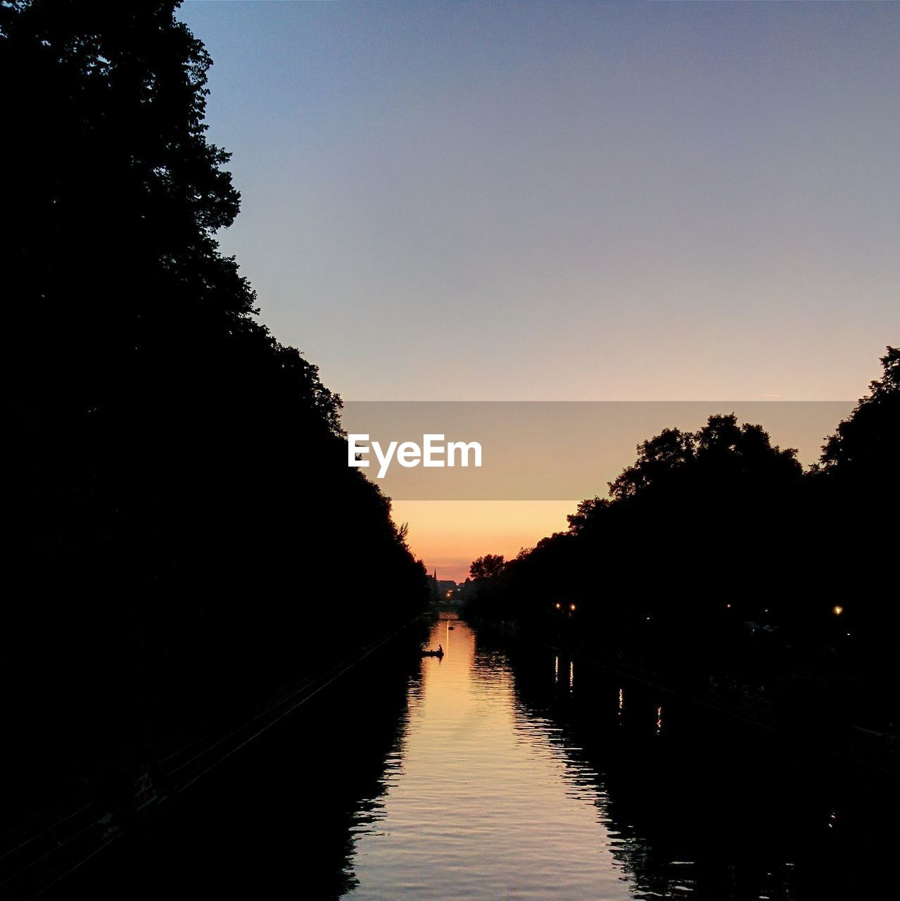 River amidst silhouette trees against clear sky