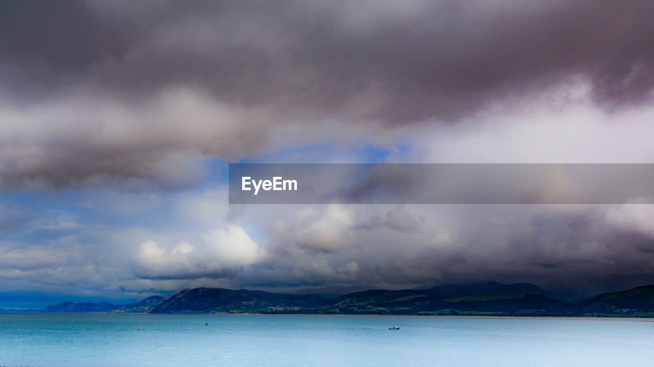 SCENIC VIEW OF SEA AGAINST STORM CLOUDS