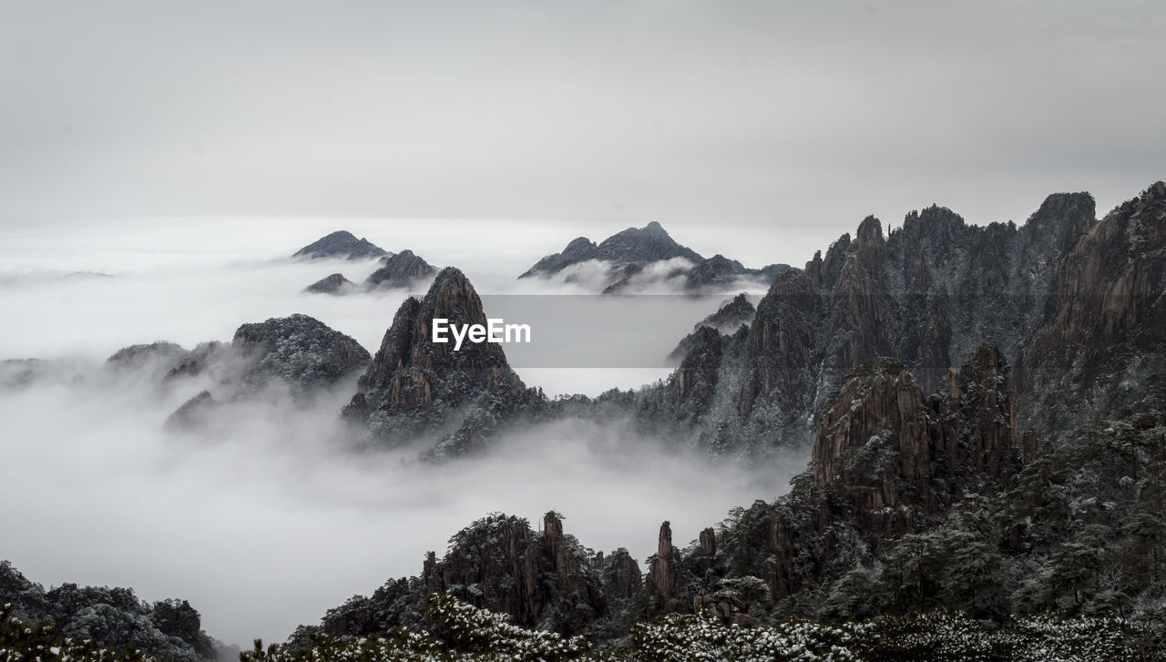 Scenic view of mountains during foggy weather against sky