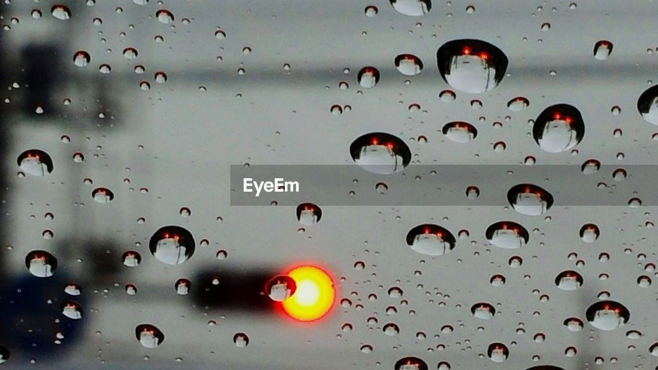 FULL FRAME SHOT OF WATER DROPS ON WINDSHIELD