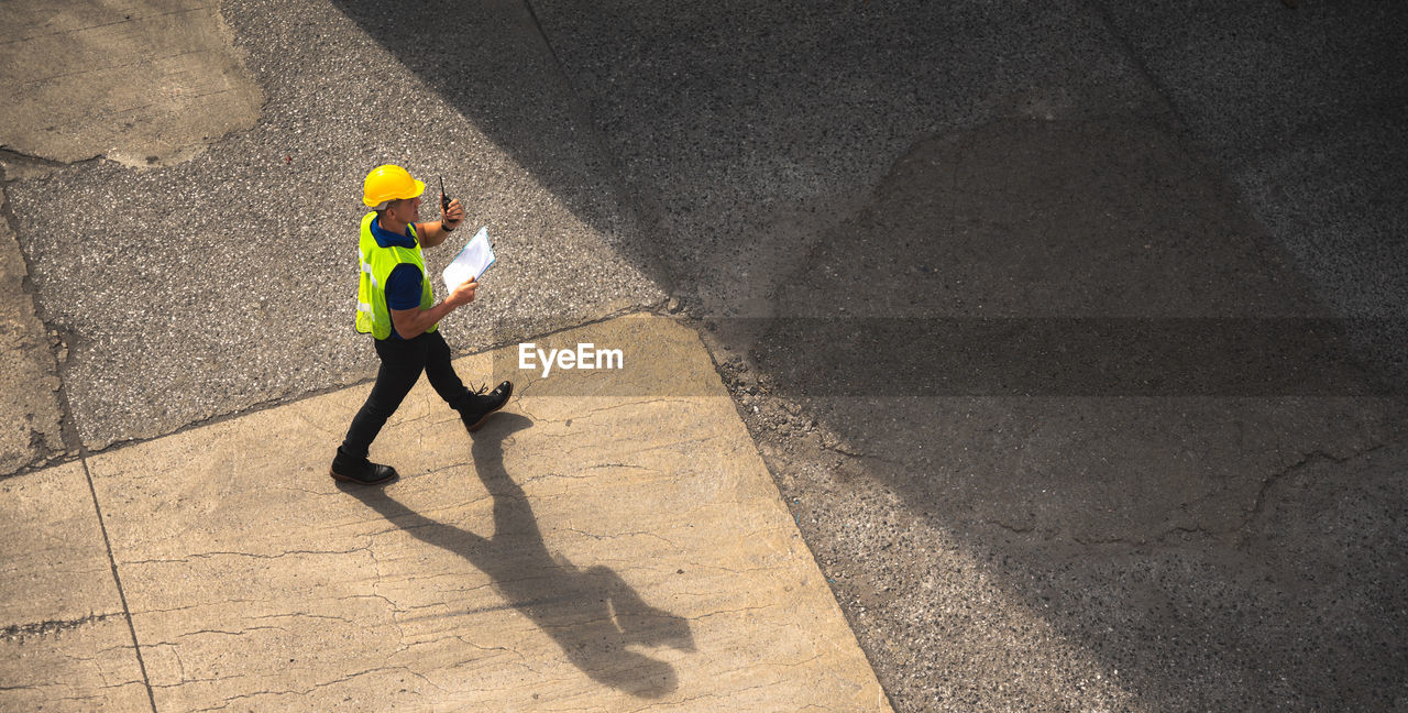 HIGH ANGLE VIEW OF MAN ON ROAD