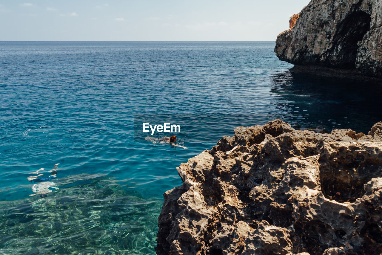 High angle view of rock formation in sea against sky