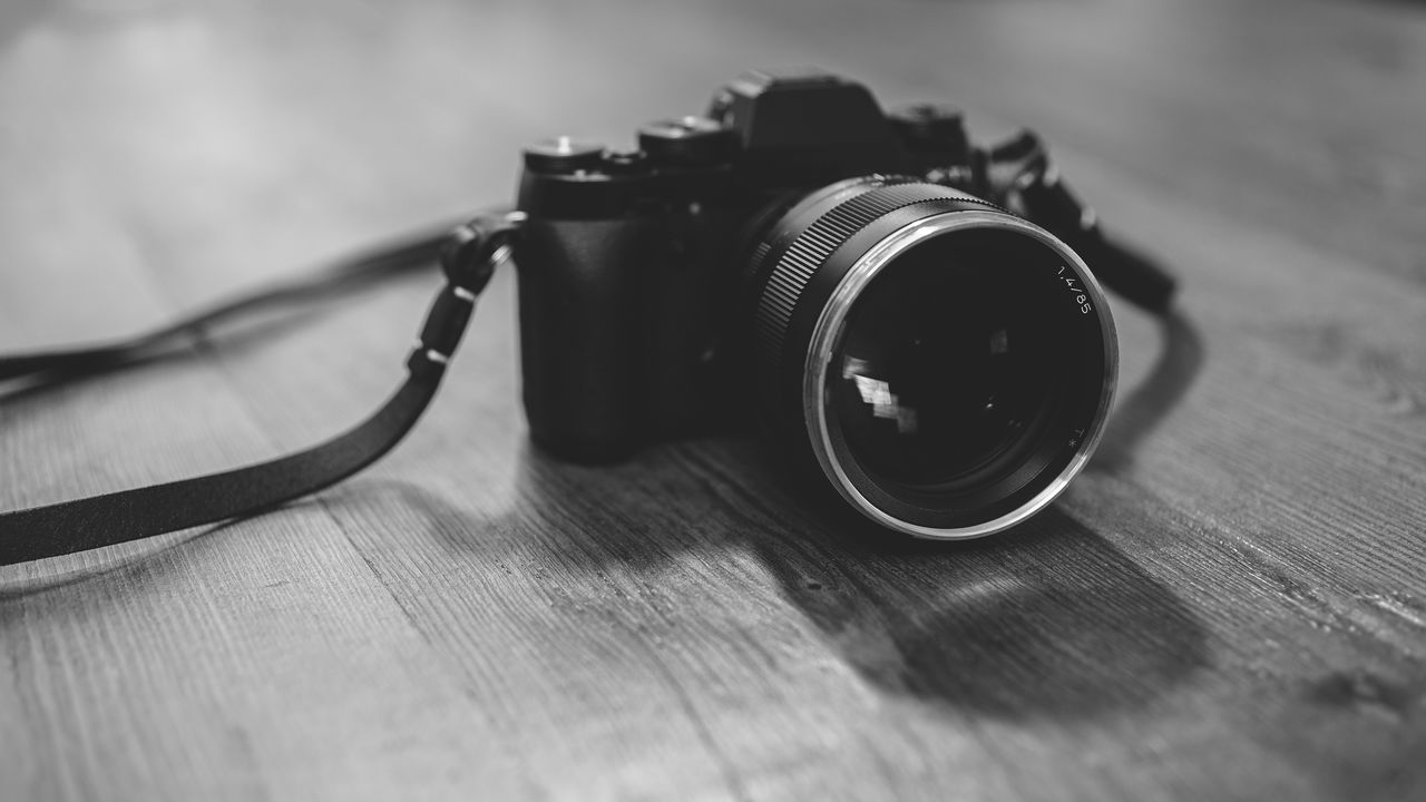 Close-up of digital camera on wooden table