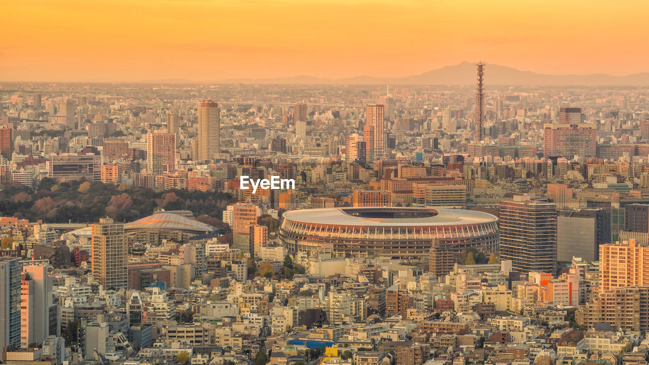 Aerial view of buildings in city against sky