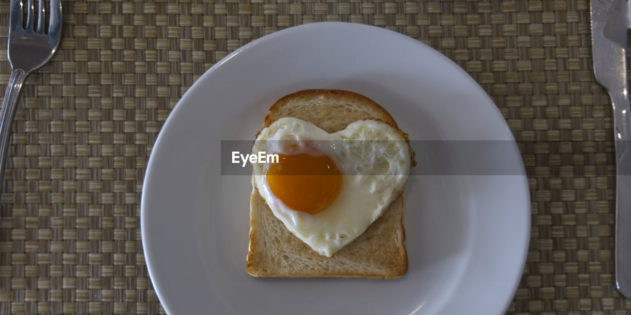 food and drink, food, egg, breakfast, meal, healthy eating, plate, kitchen utensil, freshness, wellbeing, bread, directly above, tableware, fork, eating utensil, indoors, table, household equipment, fried egg, dish, high angle view, knife, fried, no people, egg yolk, table knife, produce, fast food, toasted bread, place setting