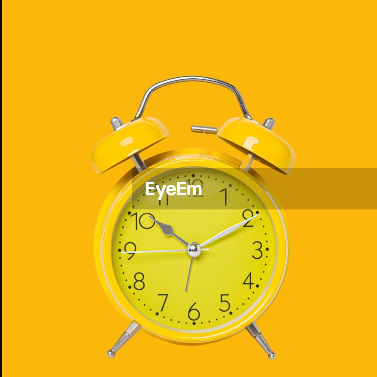 CLOSE-UP OF CLOCK OVER YELLOW BACKGROUND