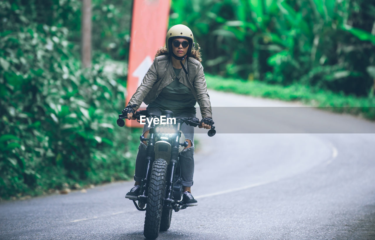 Woman riding motorcycle on road