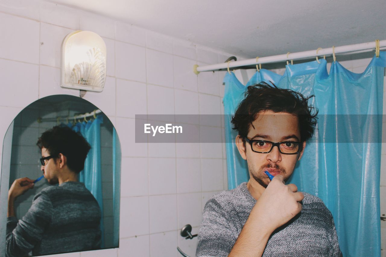 PORTRAIT OF YOUNG MAN WITH REFLECTION ON MIRROR