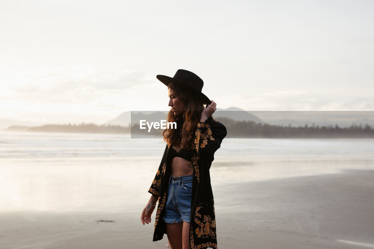 Beautiful, stylish woman on cox bay beach in tofino