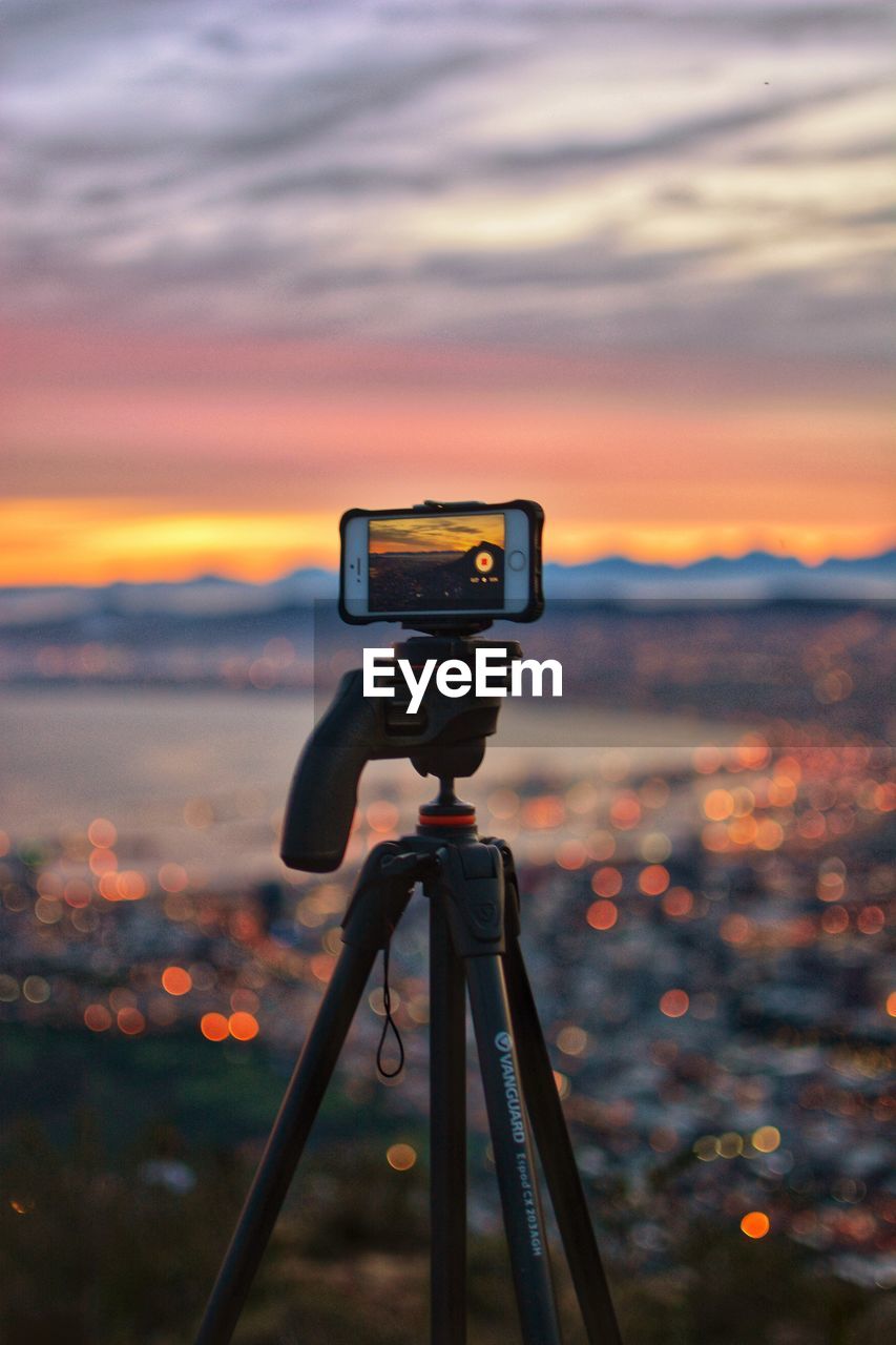 CLOSE-UP OF CAMERA AGAINST ORANGE SKY