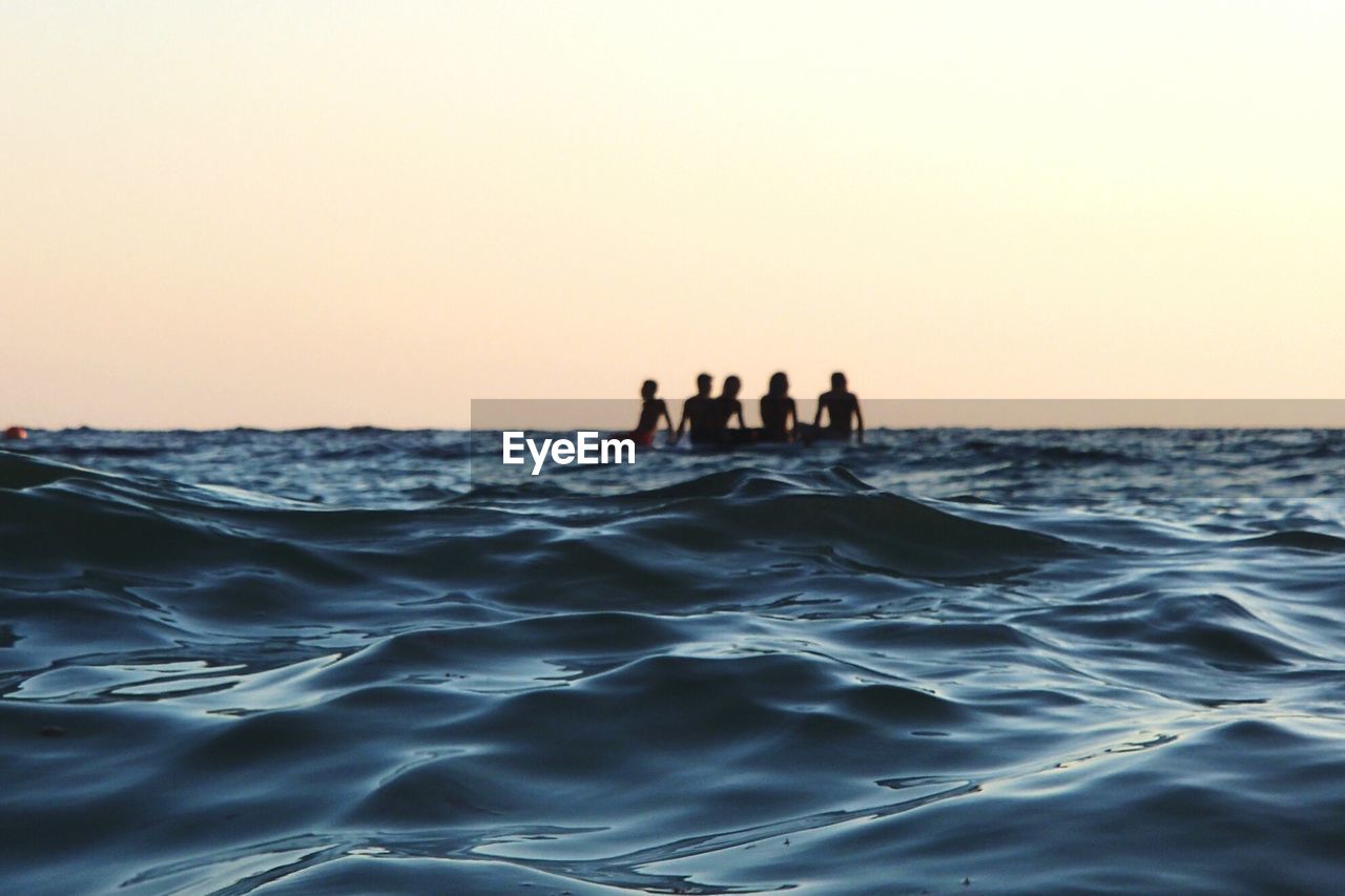 People on boat amidst sea against sky