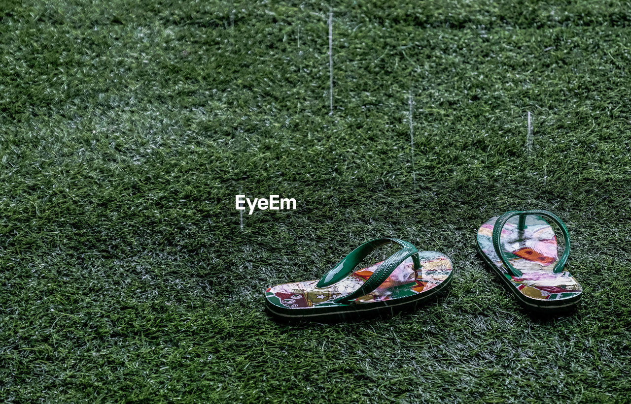 HIGH ANGLE VIEW OF SHOES ON FIELD BY LAND