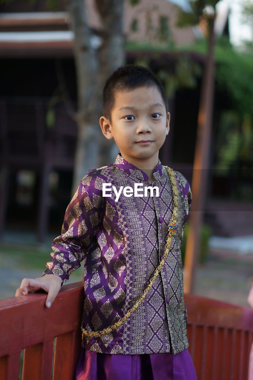PORTRAIT OF GIRL STANDING AGAINST PURPLE OUTDOORS