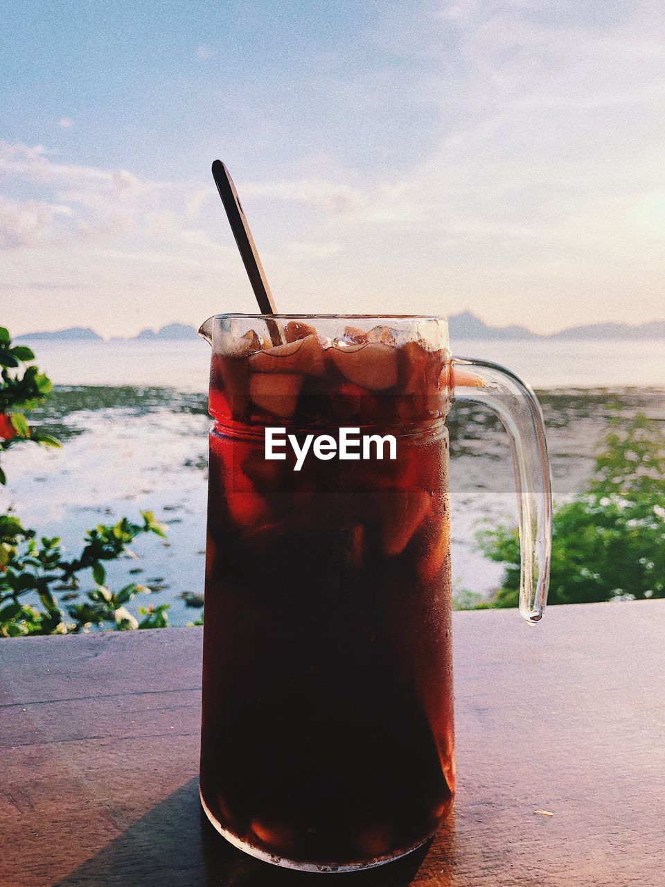 Drink in glass on table against sky