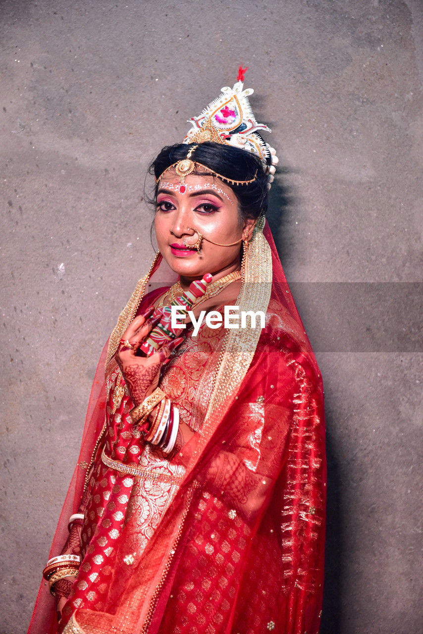 Portrait of a young woman who wearing a wedding costume in indian traditional wedding culture.