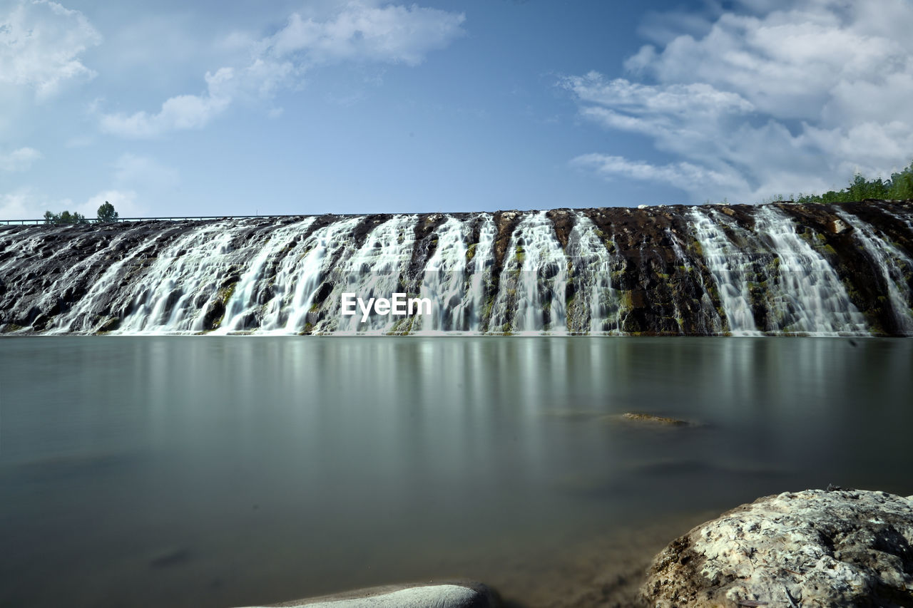 Panoramic view of waterfall against sky