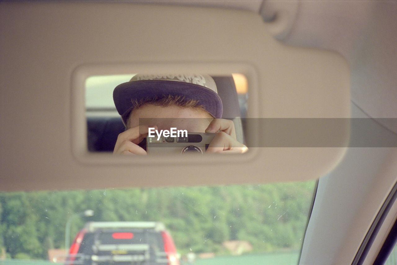 Man photographing through smart phone in car