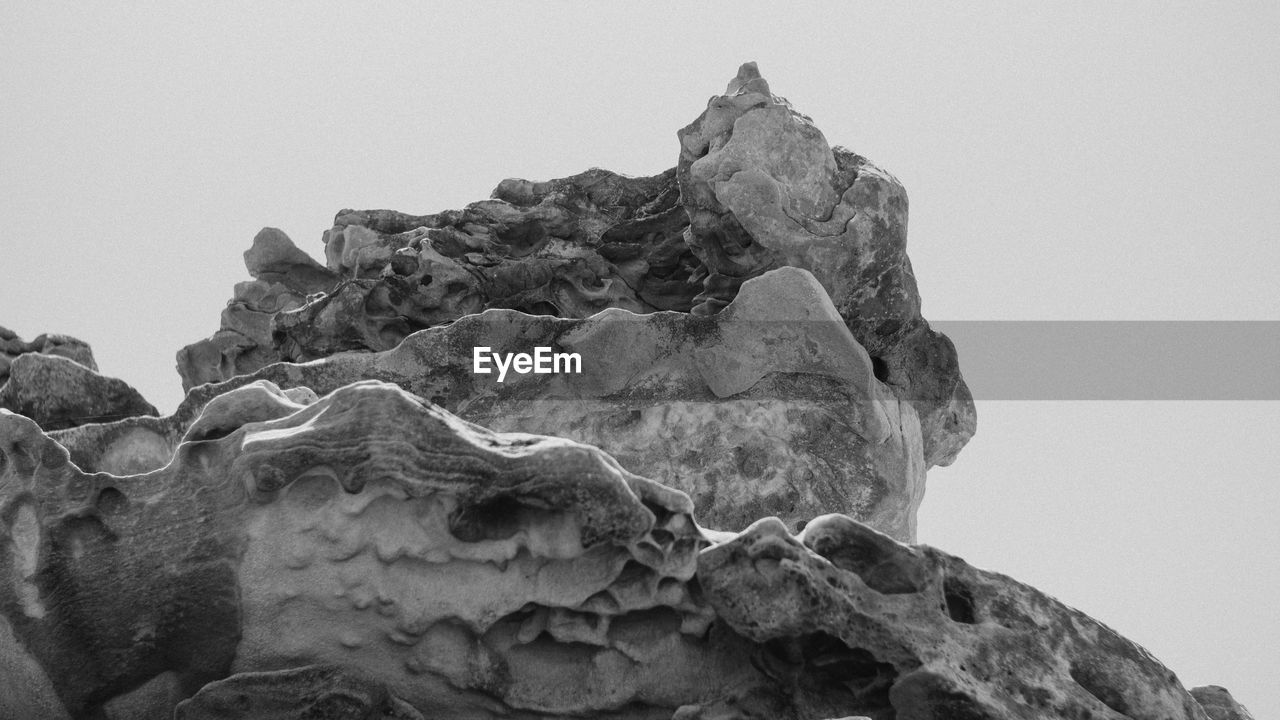 LOW ANGLE VIEW OF ROCK FORMATION AGAINST SKY