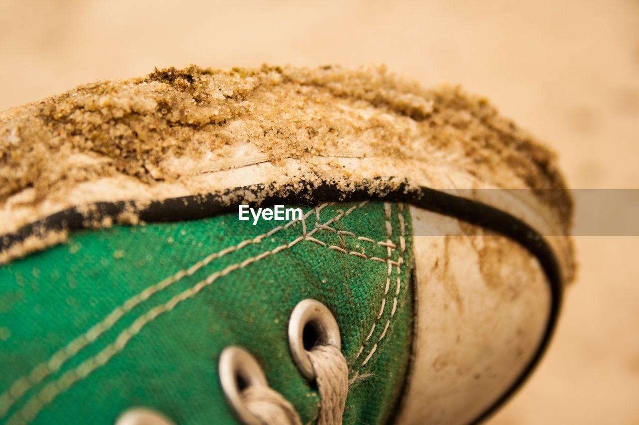 Close-up of dirty green shoe