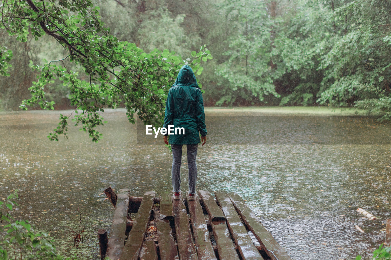 FULL LENGTH REAR VIEW OF MAN WALKING IN LAKE