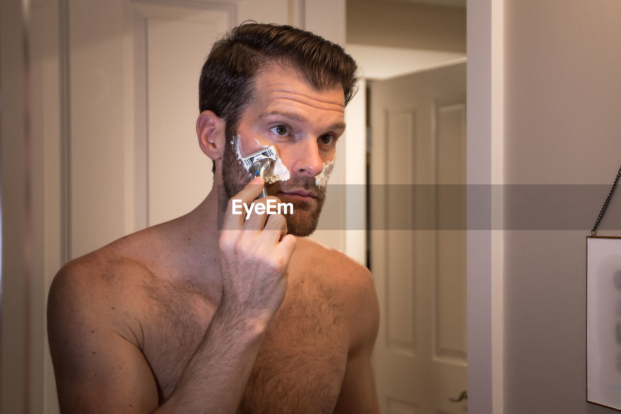 PORTRAIT OF A YOUNG MAN HOLDING A BATHROOM