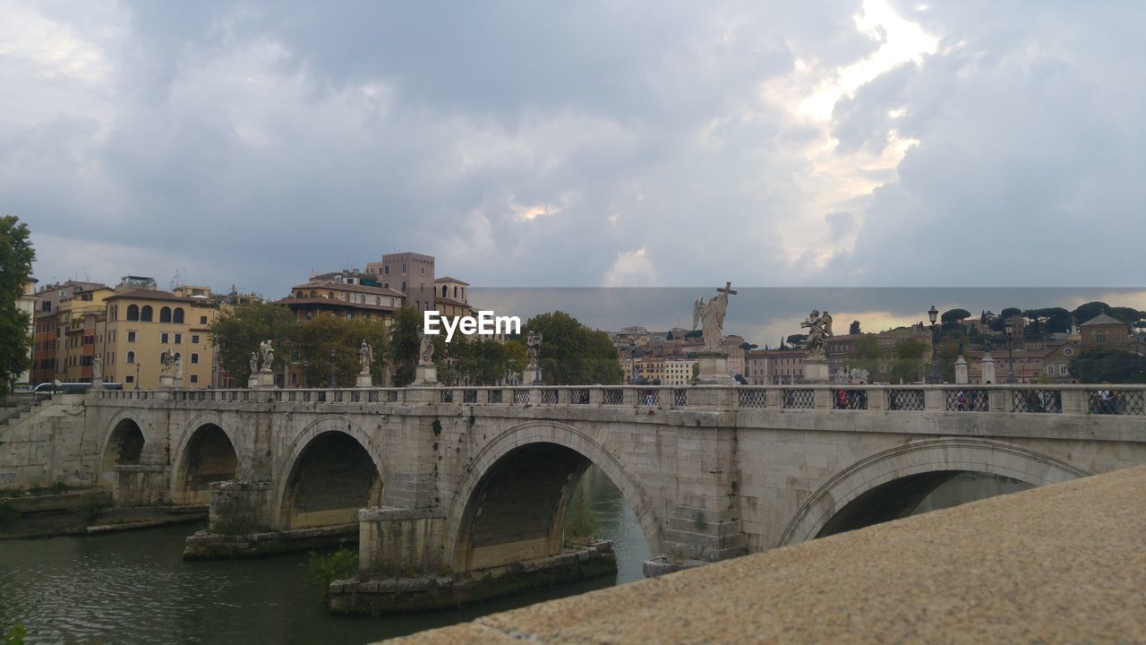 BRIDGE OVER RIVER IN CITY AGAINST SKY